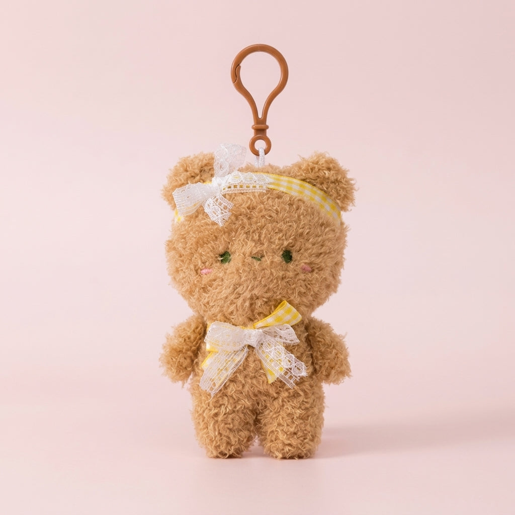 Brown plush teddy bag charm on a soft pink background