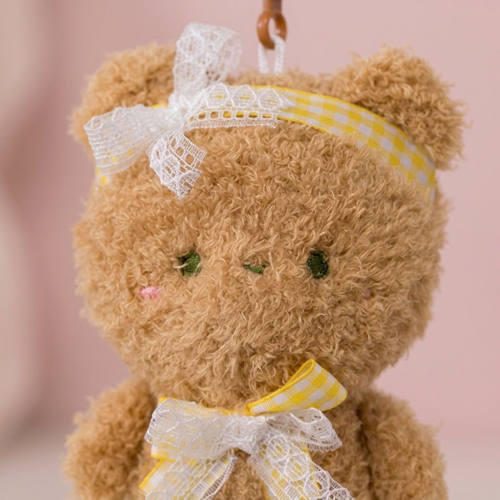 Close-up of the teddy charm's fuzzy plush fur and lace gingham bows